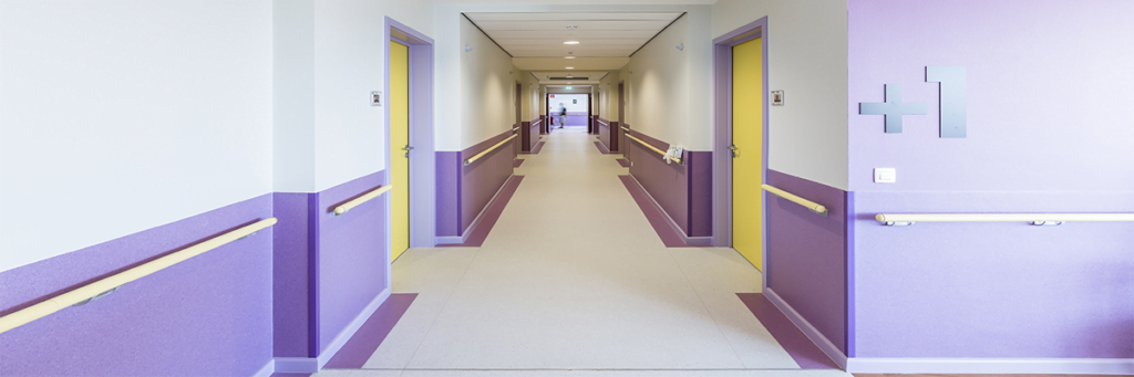 Hospital corridor with purple wall and door protection